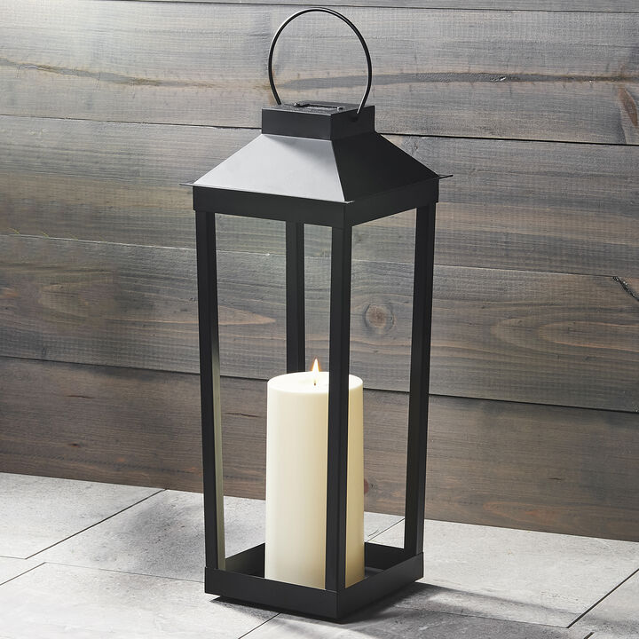black solar lantern with a white candle inside 