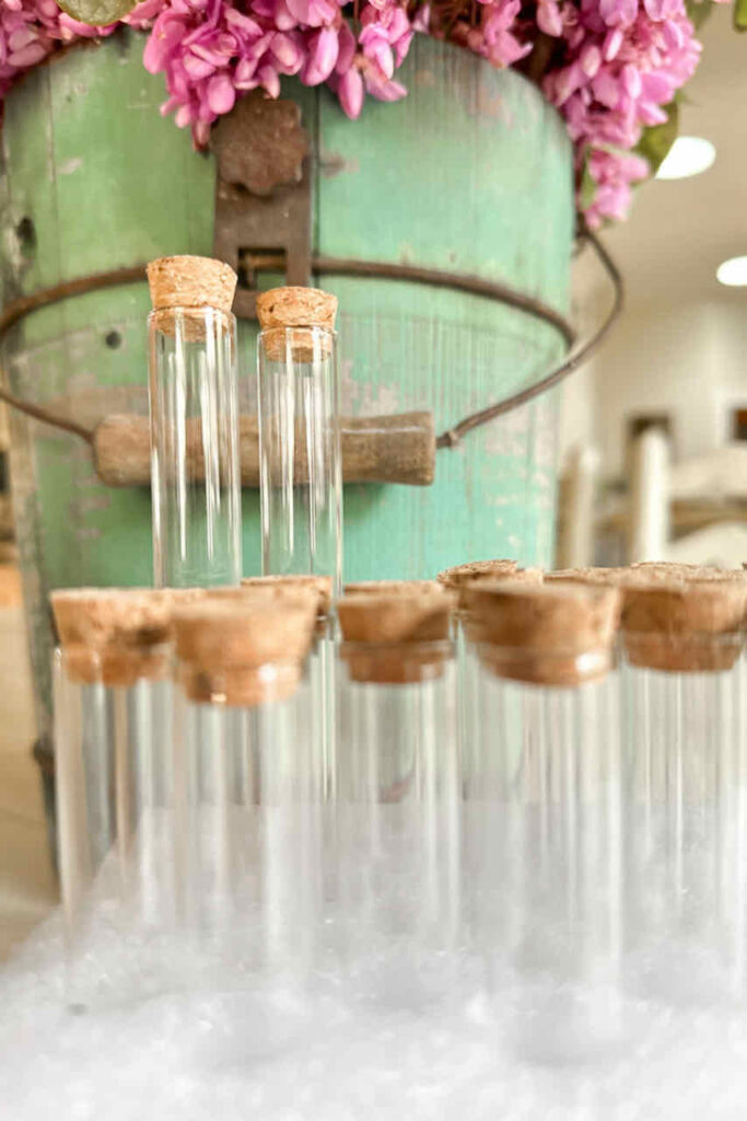 Sweet Pea flower arrangements-Test tubes sitting in front of a green wooden bucket