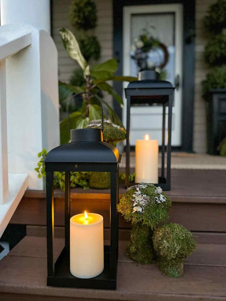 DIY spring front porch decor- solar lanterns lit on the steps of the porch with fresh moss mushrooms.