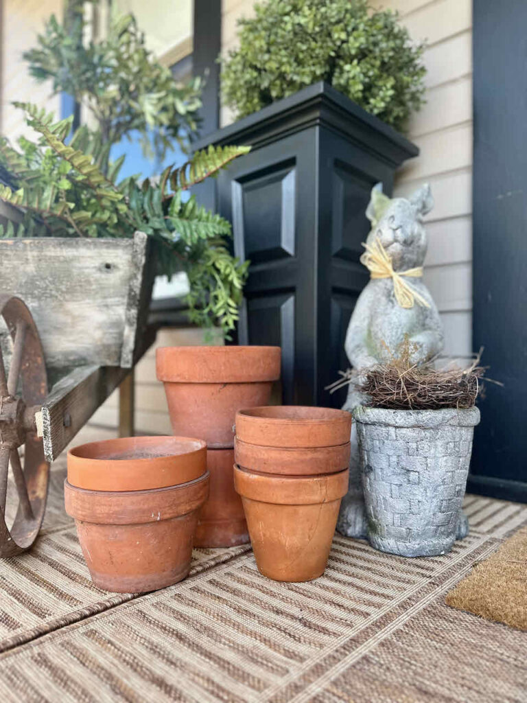 Terra cotta pots stacked on the front porch for spring deocr. 