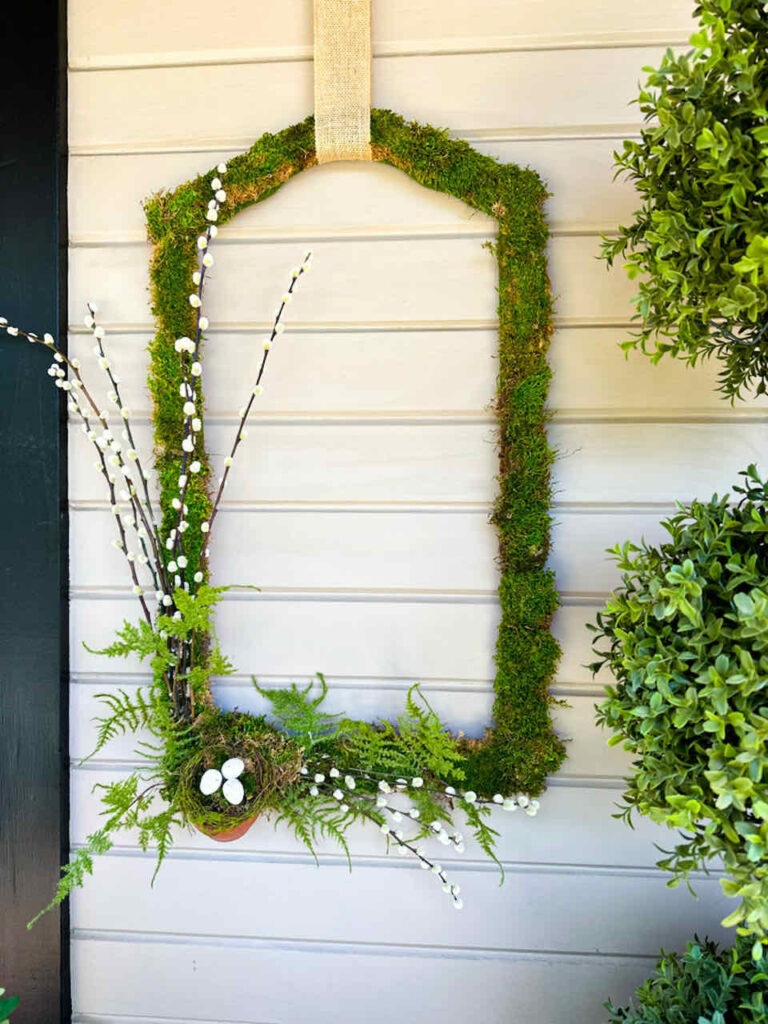 How to Make An Easy DIY Moss Frame Wall Art Gallery- A vintage picture frame covered with greem moss and decorated with pussy willows, ferns and a small clay pot with a birds nest inside.