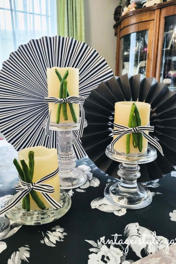 SET OF THREE CANDLES WITH BLACK AND WHITE FANS AND GREEN BEANS TIED TO THE CANDLES