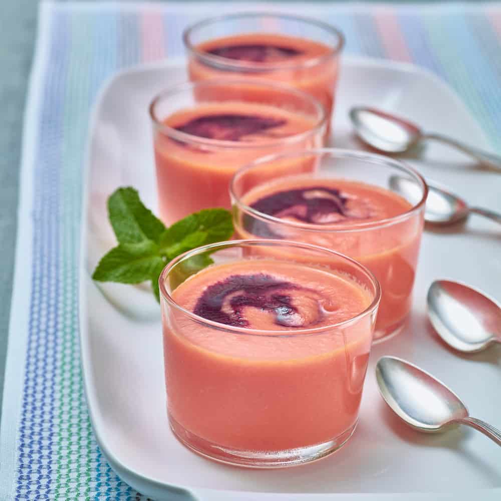 four bowls of chilled watermelon soup on a tray 