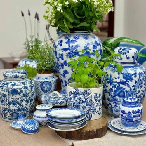 Blue and white ginger jars on the dining room table filled with green plants