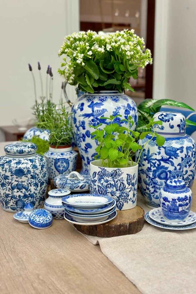 Blue and white ginger jars on the dining room table filled with green plants