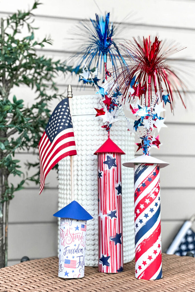 Rockets made of Toilet paper  and paper towel cardboard inners. Wrapped in festive patriotic papers with sparkling stars coming out the top. 