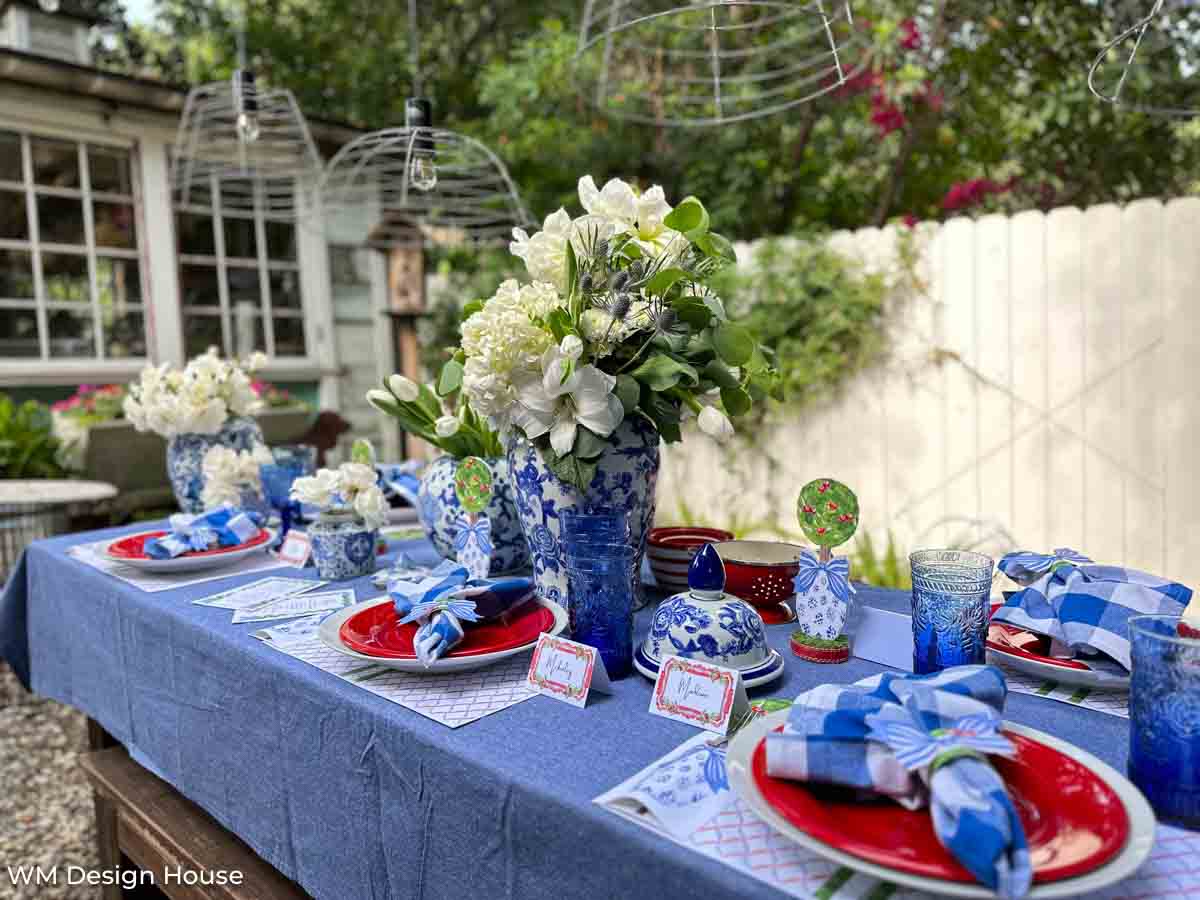 4th of July backyard dinner party with red, white, and blue dishes and blue and white pottery decorations