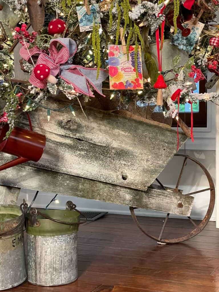 Vintage garden decor indoors- Wooden wheelbarrow with Christmas tree in it.