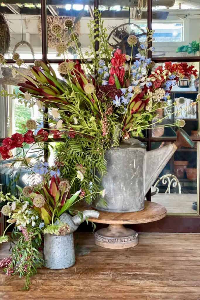 The Best Vintage Garden Decor Ideas For Indoors- galvanized watering can and galvanized oil can filled with flowers