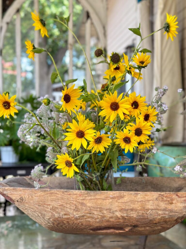 DIY wildflower floral arrangement small yellow sunflowers in an arrangement that is sitting in a dough bowl