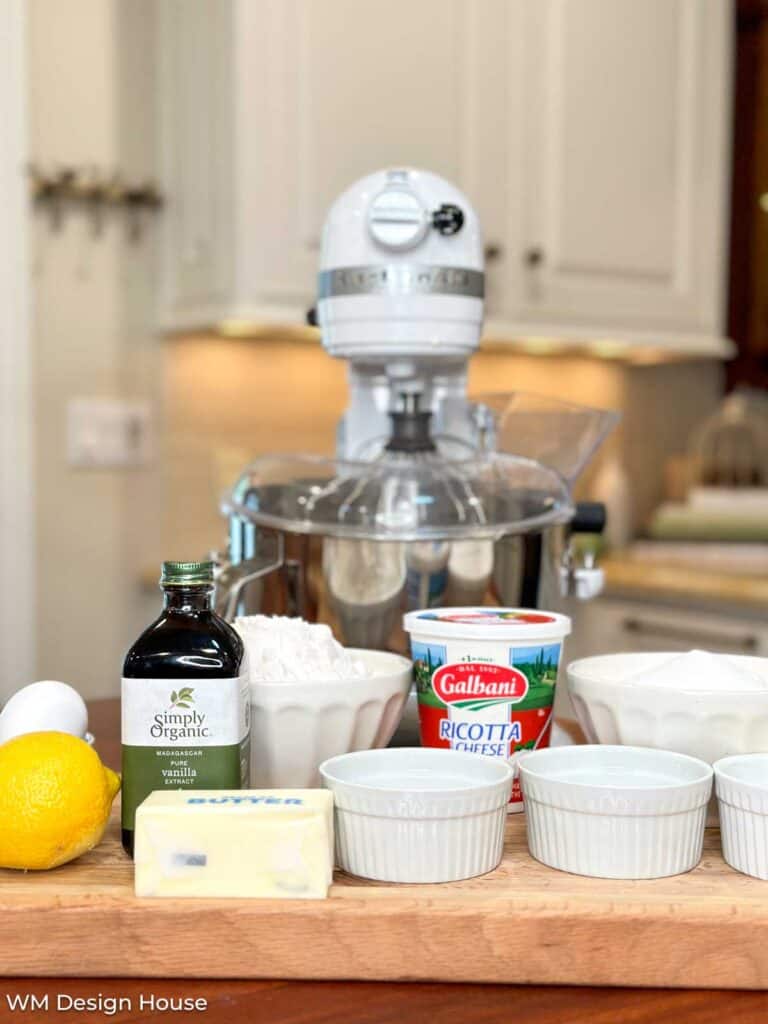 A mixer on the kitchen counter with all of the ingredients to make the lemon ricotta chees cookies 