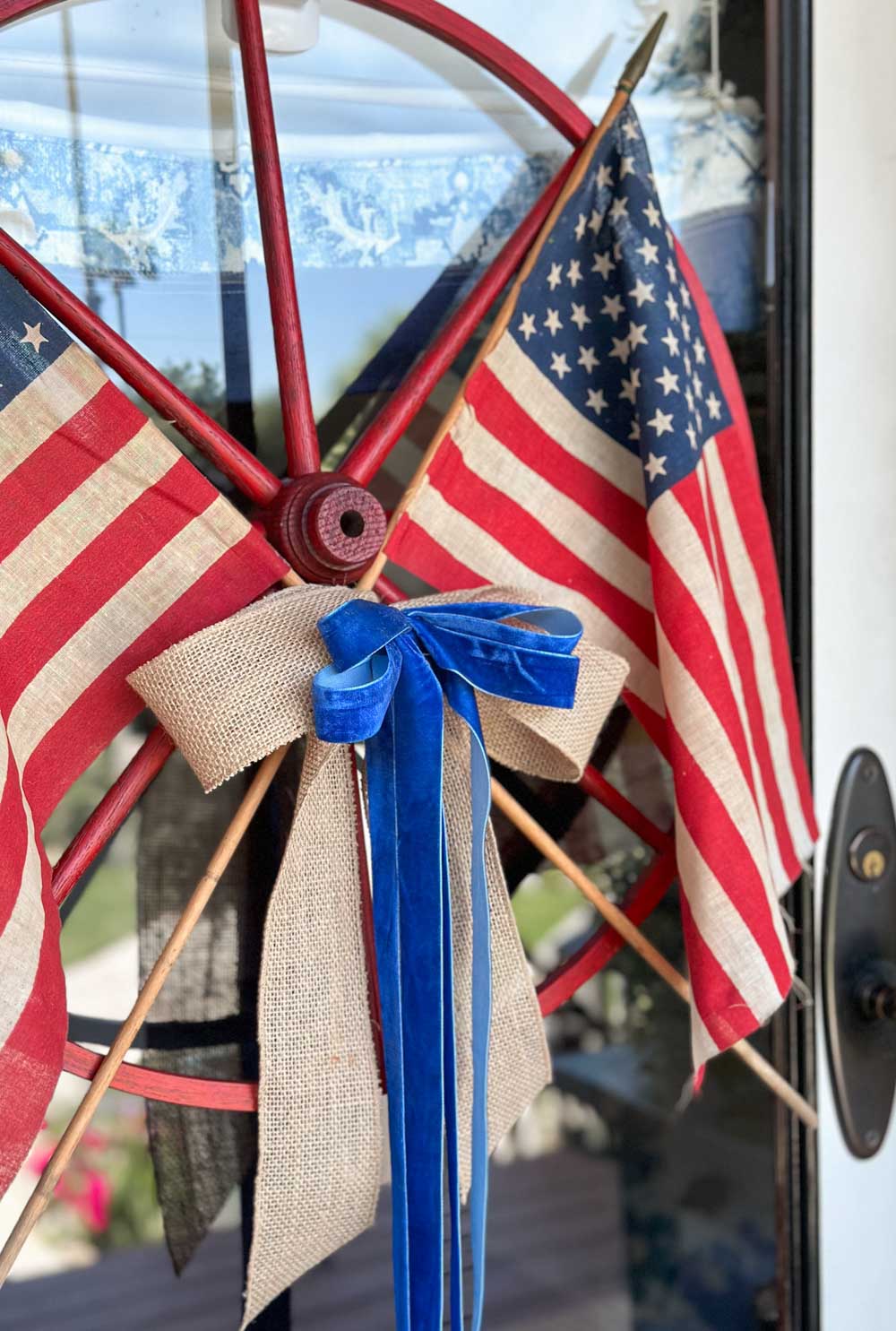 DIY wagon wheel wreath with American flags and a patriotic bow 