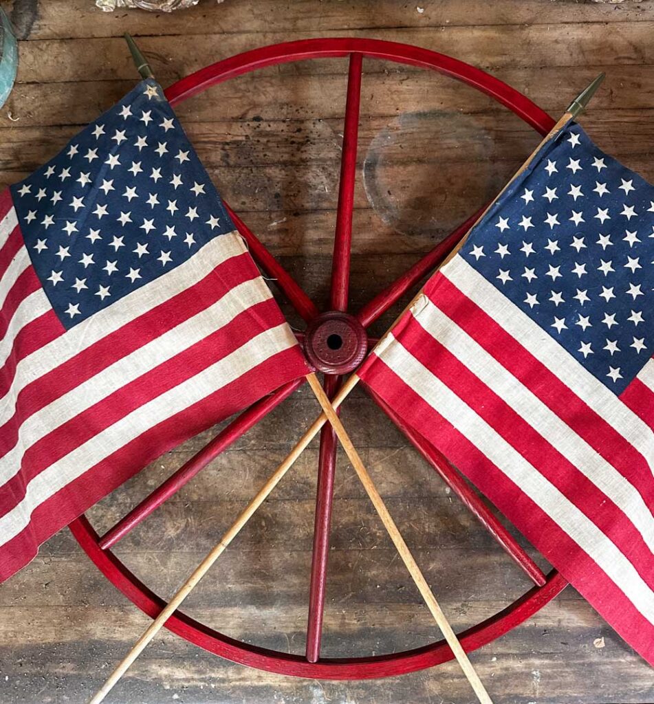 How to make a DIY wagon wheel wreath- two flags being attached to the wheel 