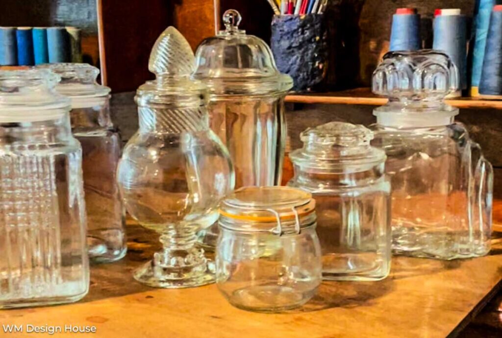 empty apothecary jars I have collected sitiing on a table 