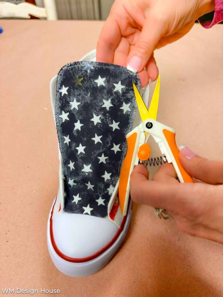 How to paint canvas shoes- removing the star stickers on the tongue of the tennis shoe after painting the background. 