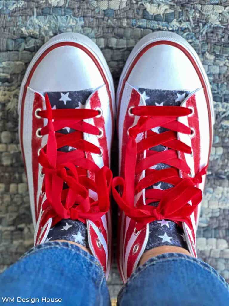 Velvet ribbon used as shoe laces on a pair of patriotic tennis shoes painted with stripes and stars. 