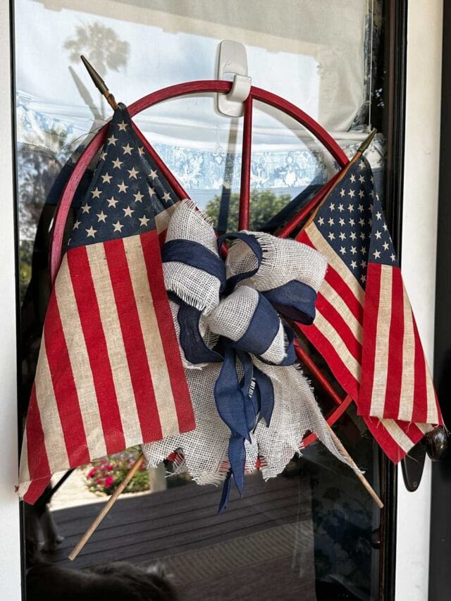 DIY Patriotic Wagon Wheel wreath with American flags and a burlap bow