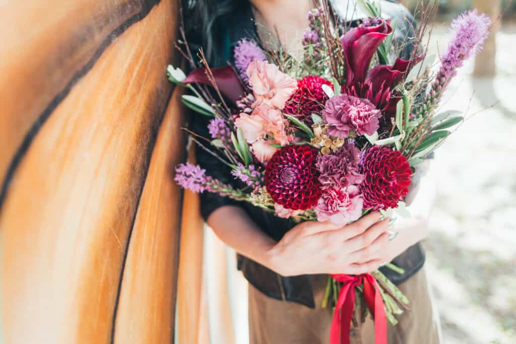 a bouquet of flowers being held by a perosn 