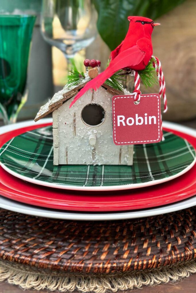 A small bird house that is used to hold a name card at a table for Christmas.