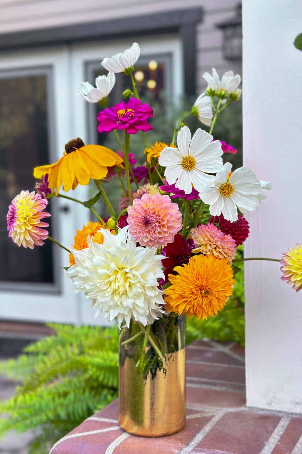 mixed bouquet of flower in a glass vase with gold foil