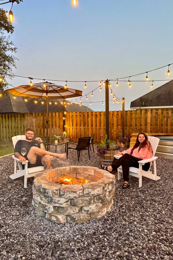 Couple sitting in the backyard enjoying their market lights and fire pit