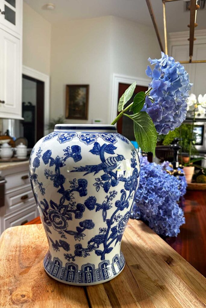   Hydrangea floral arrangements- blue and white large vase with blue hydrangea in it 