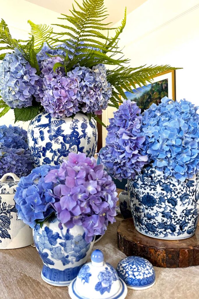 table with several arrangements of blue hydrangeas on the table