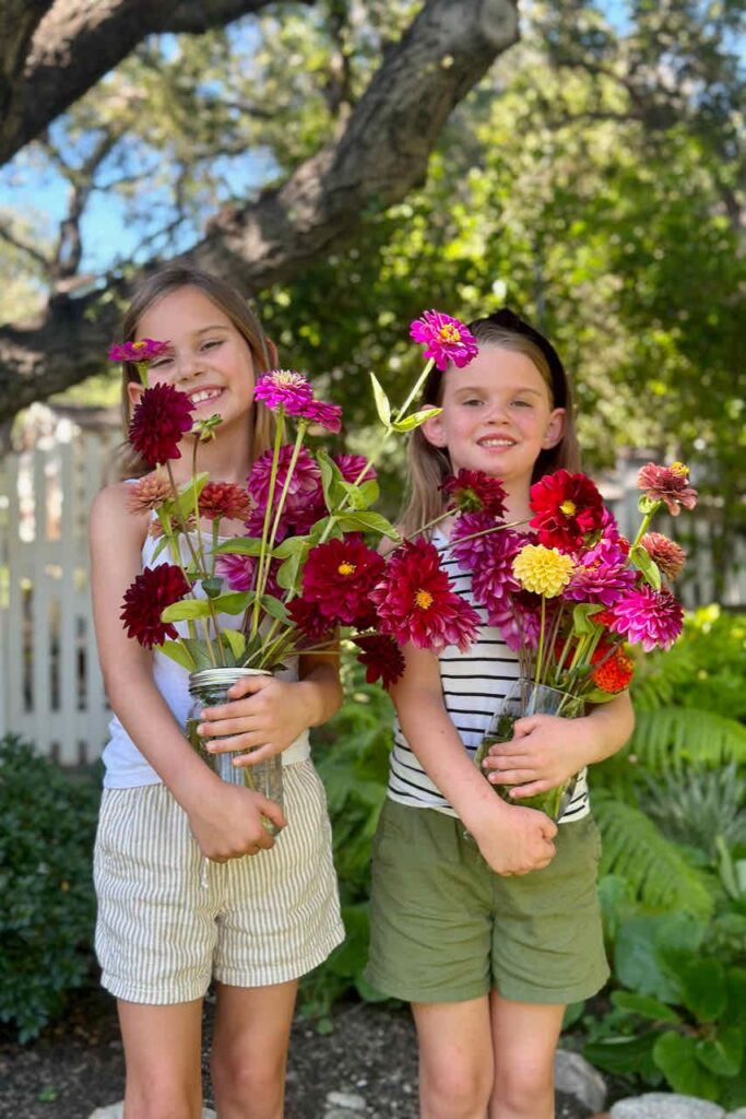 Girls holding flower arrangements that they made for the pop up flower market. 