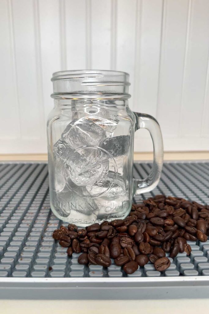 A mason jar filled with ice in preparing to make a coffee drink 