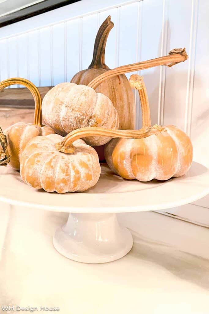 Terra cotta pumpkins on a ceramic cake plate 