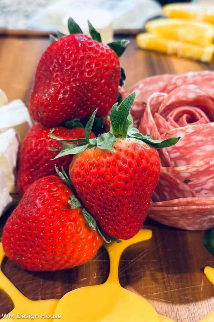 Fresh strawberries on a charcuterie board.