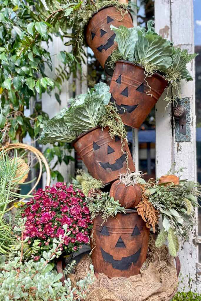 Cinnamon bucket topiary for fall. buckets are cut out to look like jack  O lanterns 