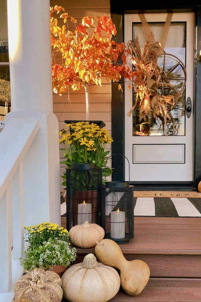Fall front porch with fall tree, lanterns and pumpkins 