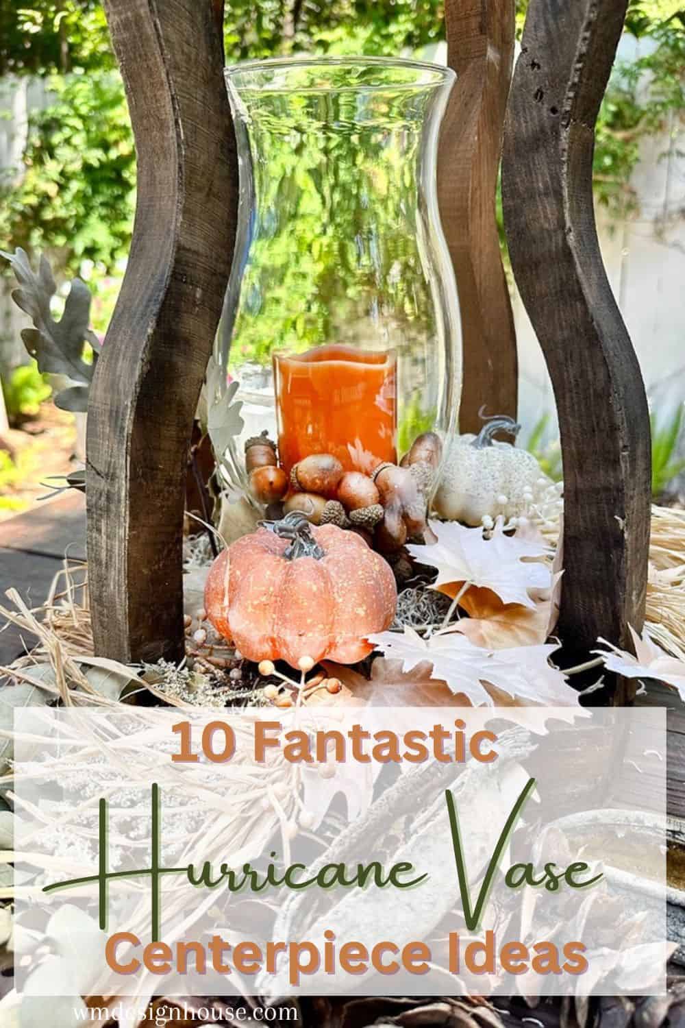 A glass hurricane vase filled with a lit orange candle and surrounded by fall decorations, including a small pumpkin, acorns, and autumn leaves. The vase is set within a wooden structure. Text overlay reads "10 Fantastic Hurricane Vase Centerpiece Ideas." Perfect for your hurricane vase for fall!