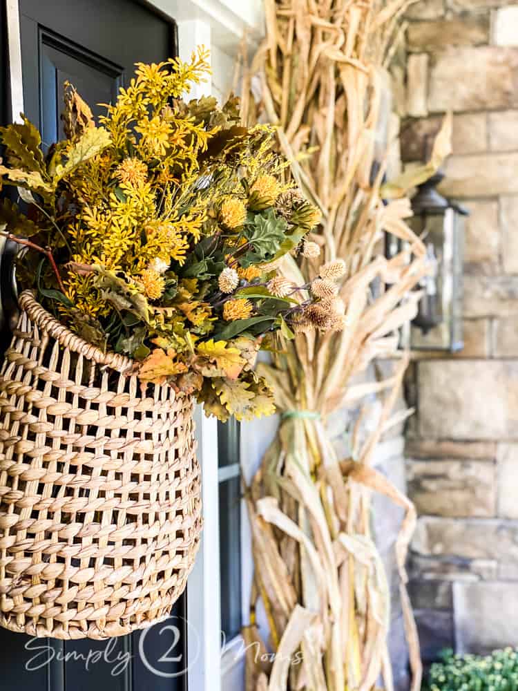 Basket hanging on the front door for fall. Filled with dried yellow flowers 