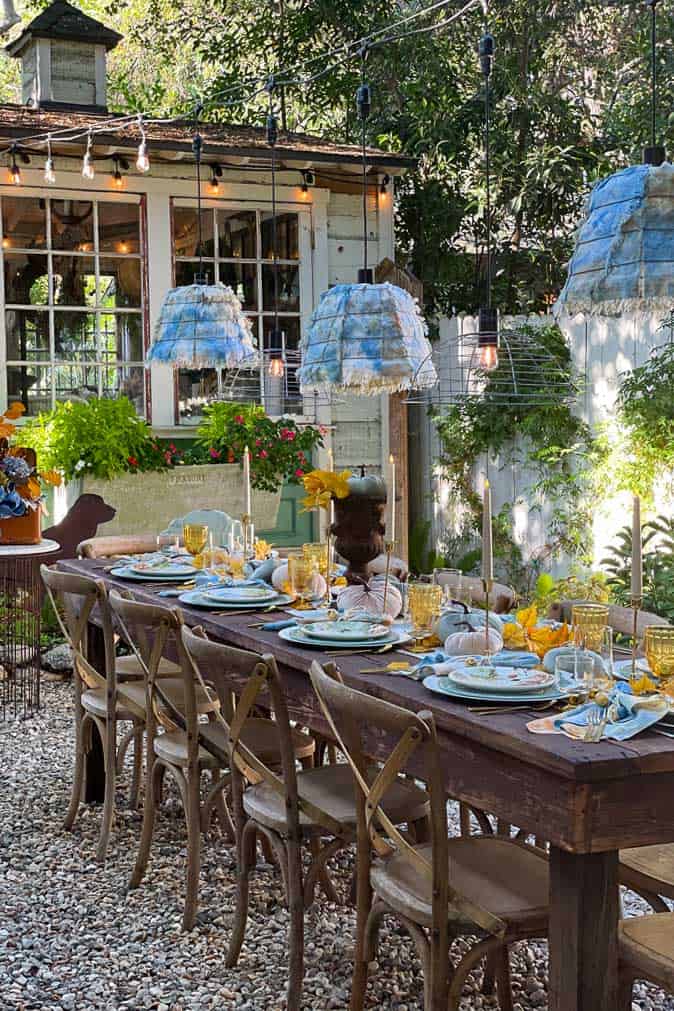 Outdoor table set for fall. Showcasing the hanging garden baskets that are used to make light fixtures.. 