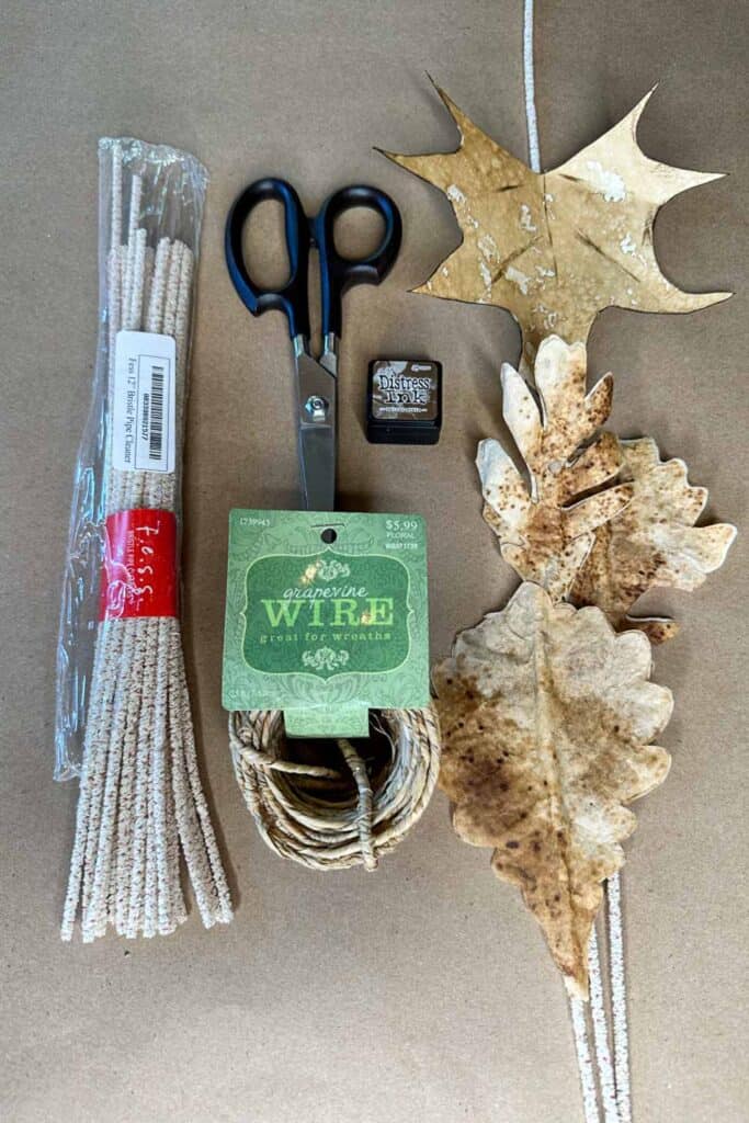 Supplies to make a coffee paper leaf garland. Scissors, pipe cleaners, distress ink and wire. 
