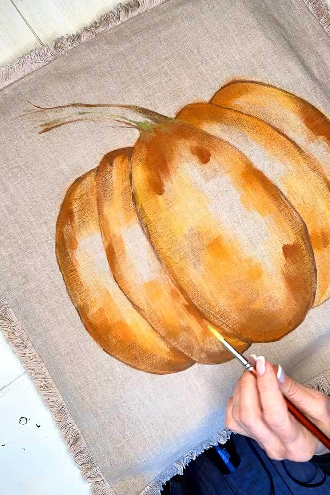 Painting a pumpkin onto a pillow case