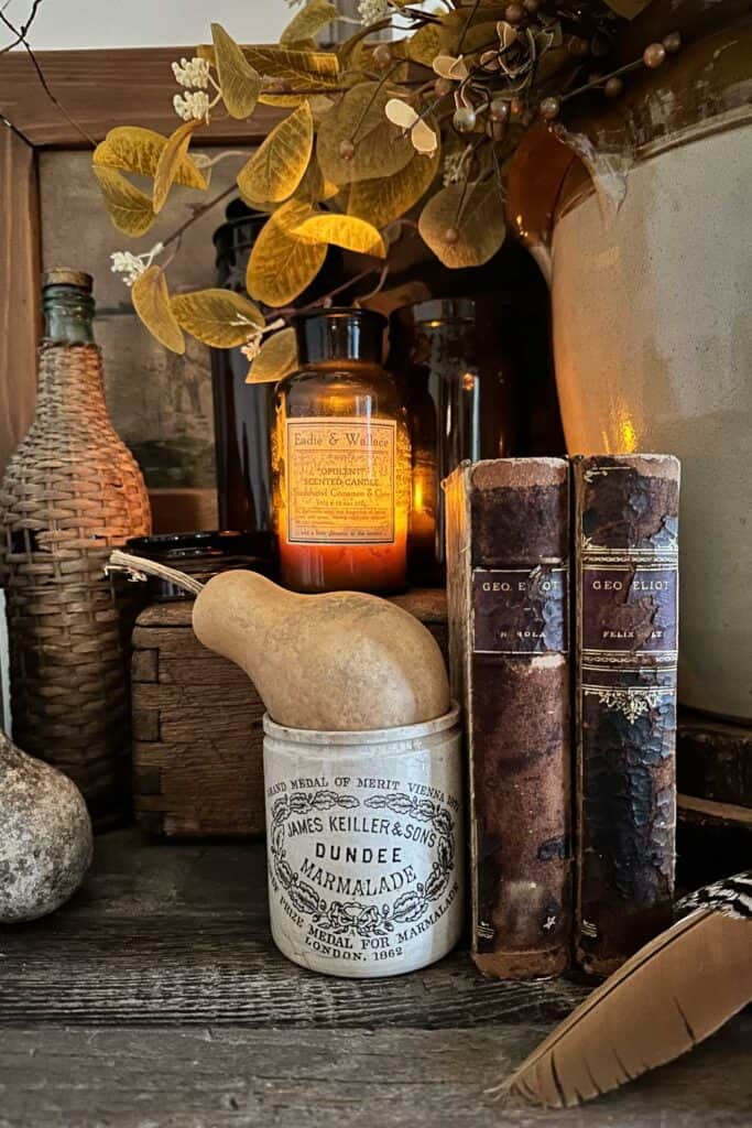 three amber glass jars with old vintage books for a fall vignette.