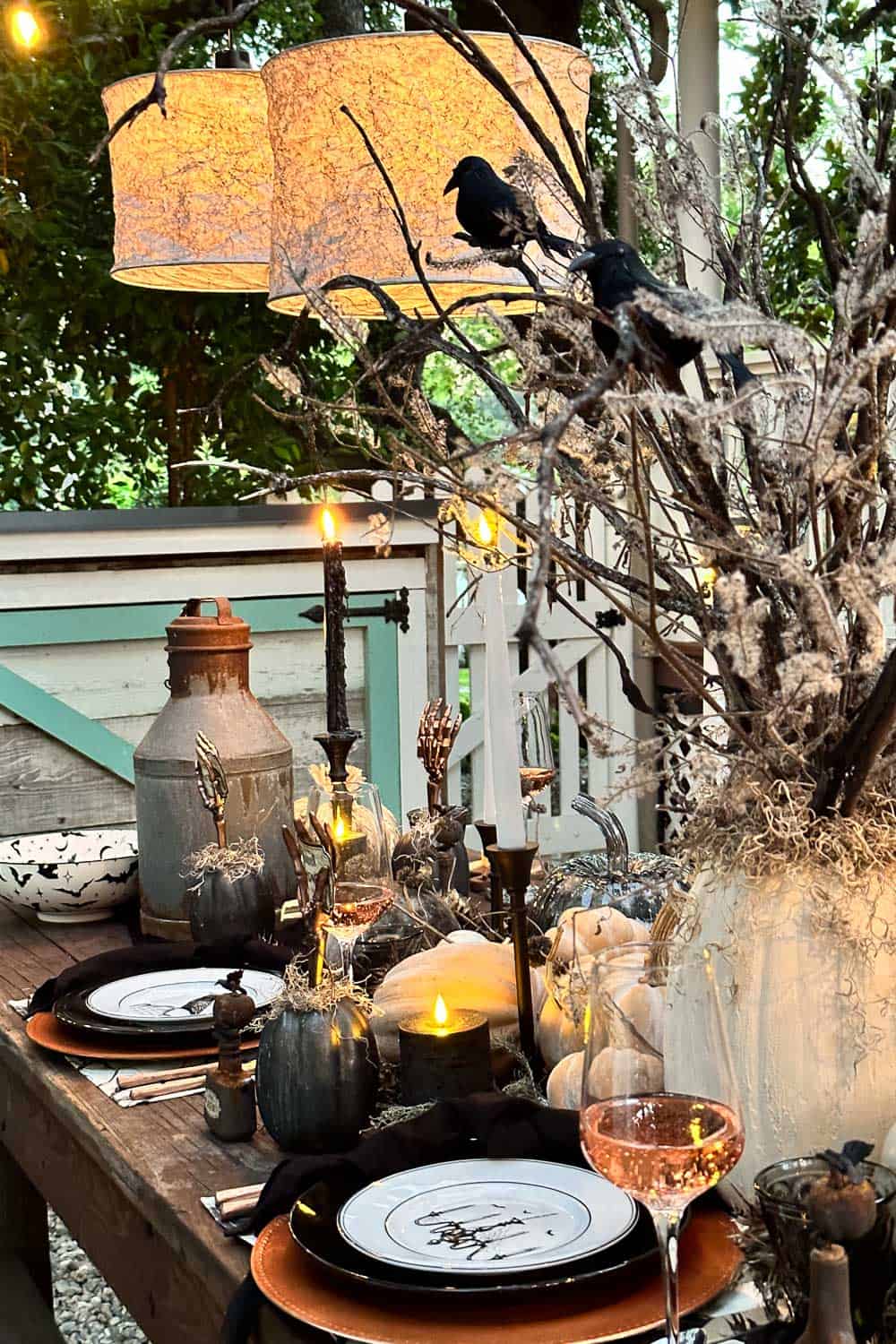 Halloween tree made with burnt foraged branches with crows perched in the branches arranged in a pumpkin vase with spanish moss