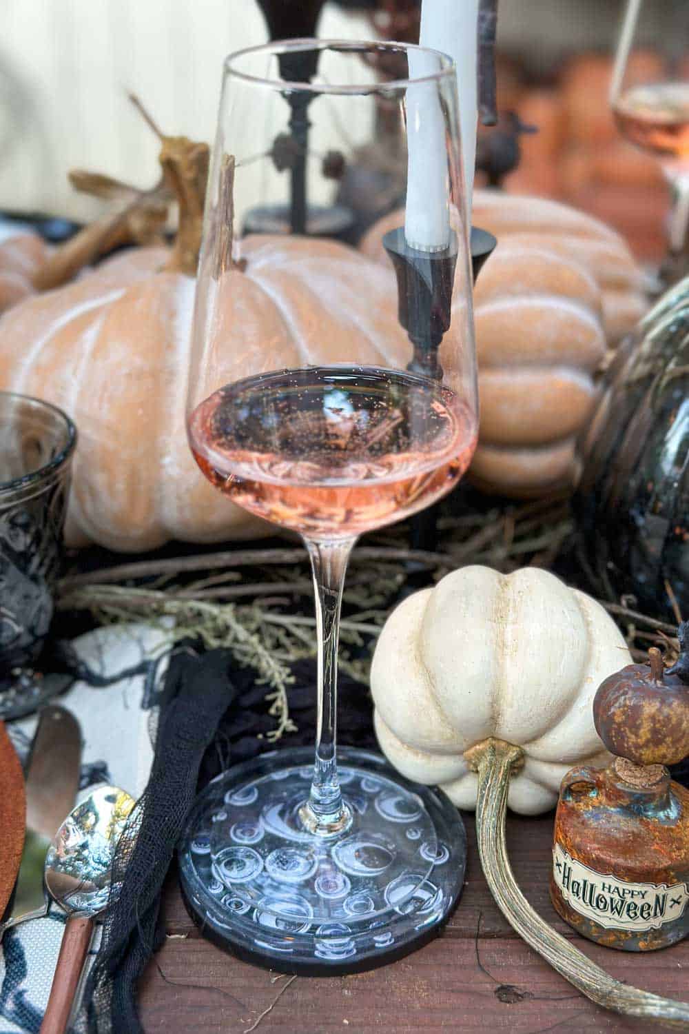 Halloween tablescape- Googley eye coasters with a wine glass sitting on top.