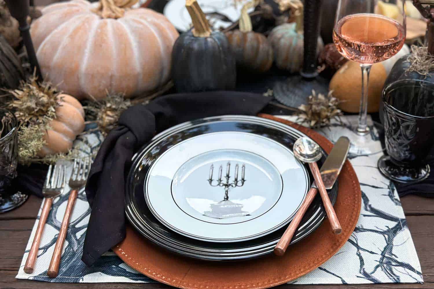 Black and orange place setting on Halloween tables cape with copper and black charger plates and Halloween salad plates