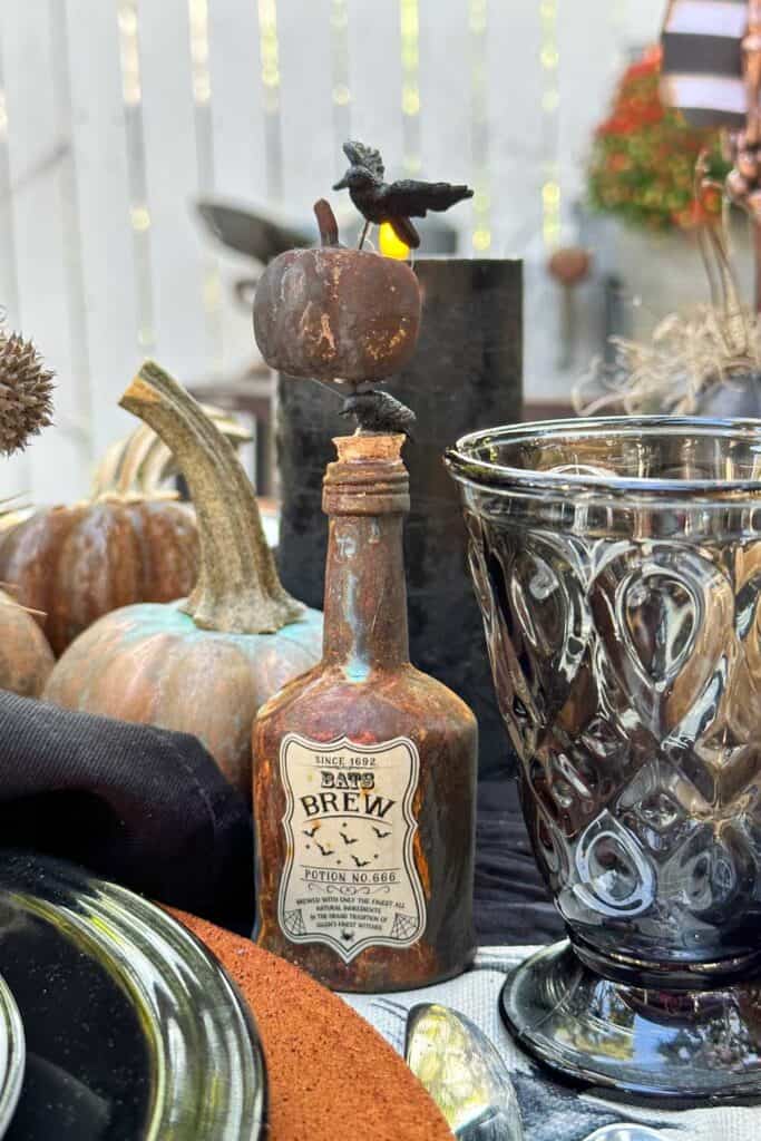 Halloween Tablescape- rusty old liquor bottle that has been painted and decorated with an apothecary label.  