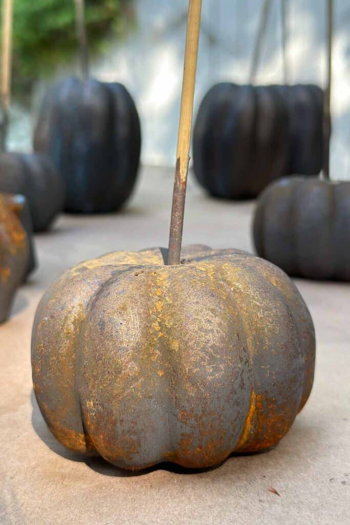A small pumpkin that has been sprayed with a rust patina. 