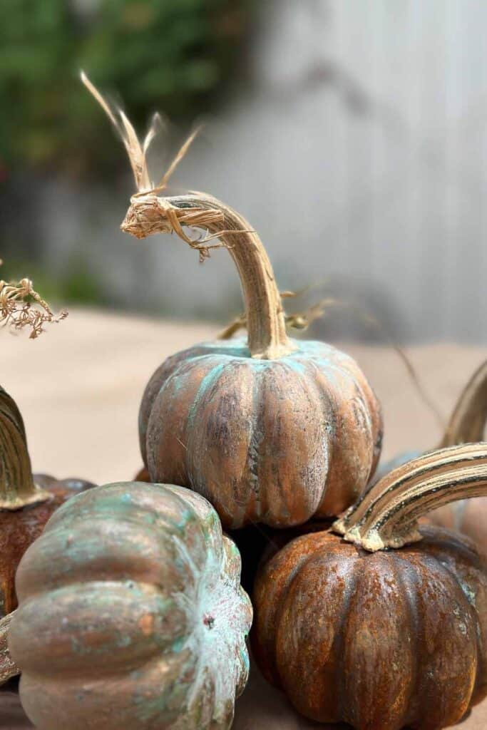 Three pumpkin that have been painted with metallic paint and sprayed with a patina