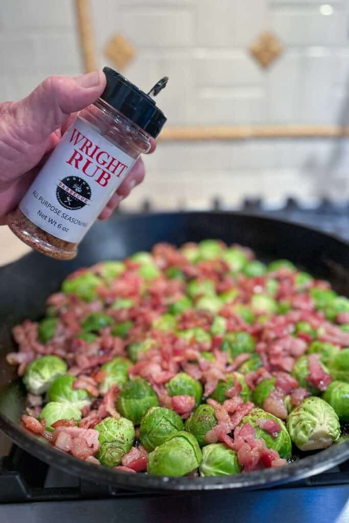 Add Wright rub to the Brussels sprouts and bacon in a cast iron pan.