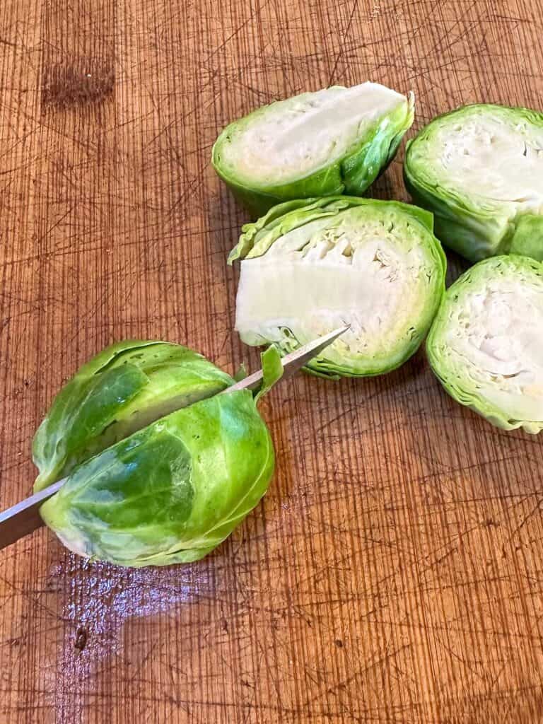 Cutting Brussels Sprouts in half.