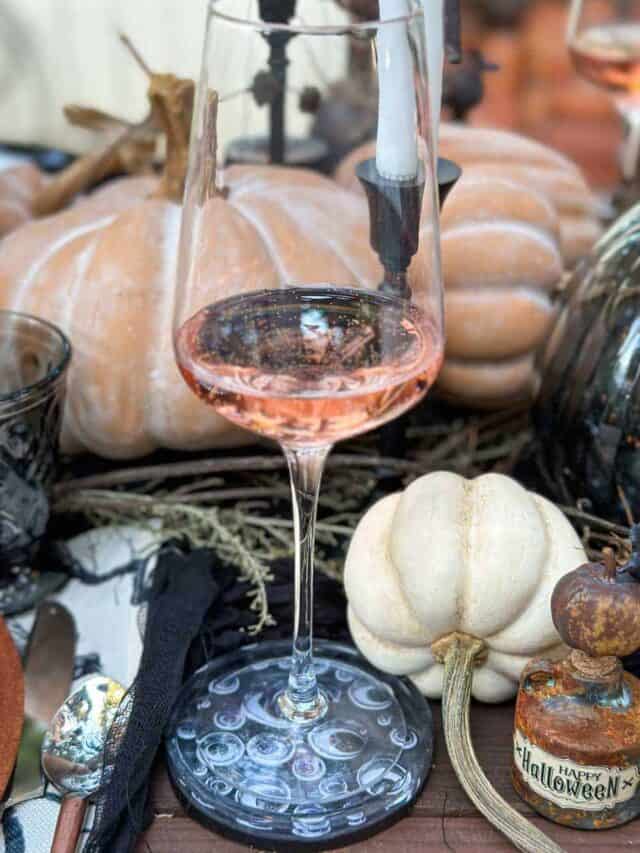Halloween tablescape- Googley eye coasters with a wine glass sitting on top.