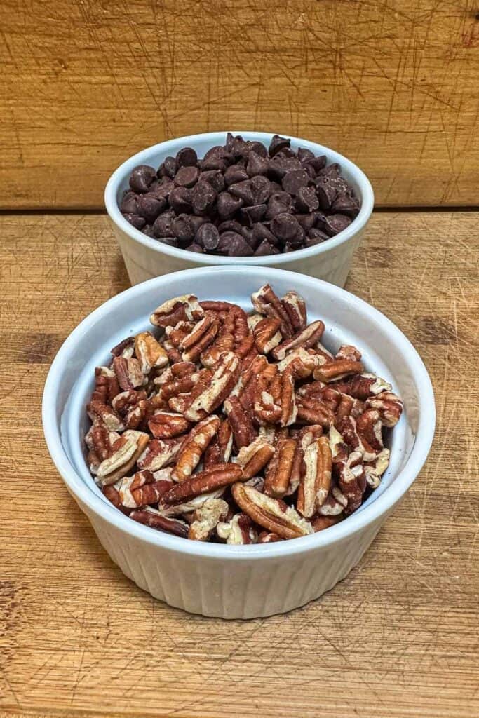 nuts and chocolate chips in a dish to add into the pumpkin cookies