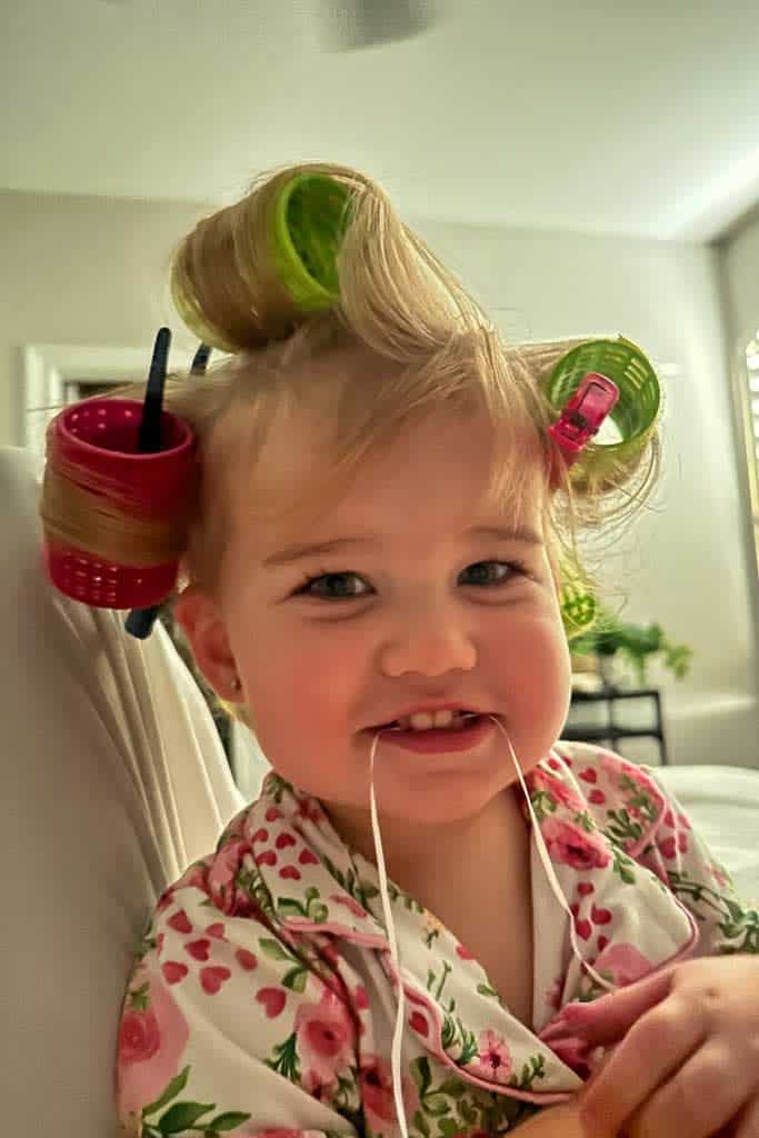 A little girl with velcro rollers in her hair.